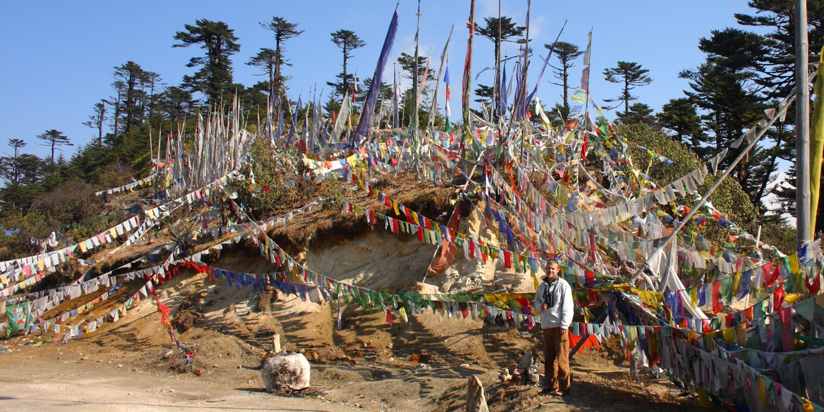 Markus Lilje bei den Gebetsflaggen in Bhutan Markus Lilje umgeben von farbenfrohen Gebetsflaggen auf einer Vogelbeobachtungstour in Bhutan