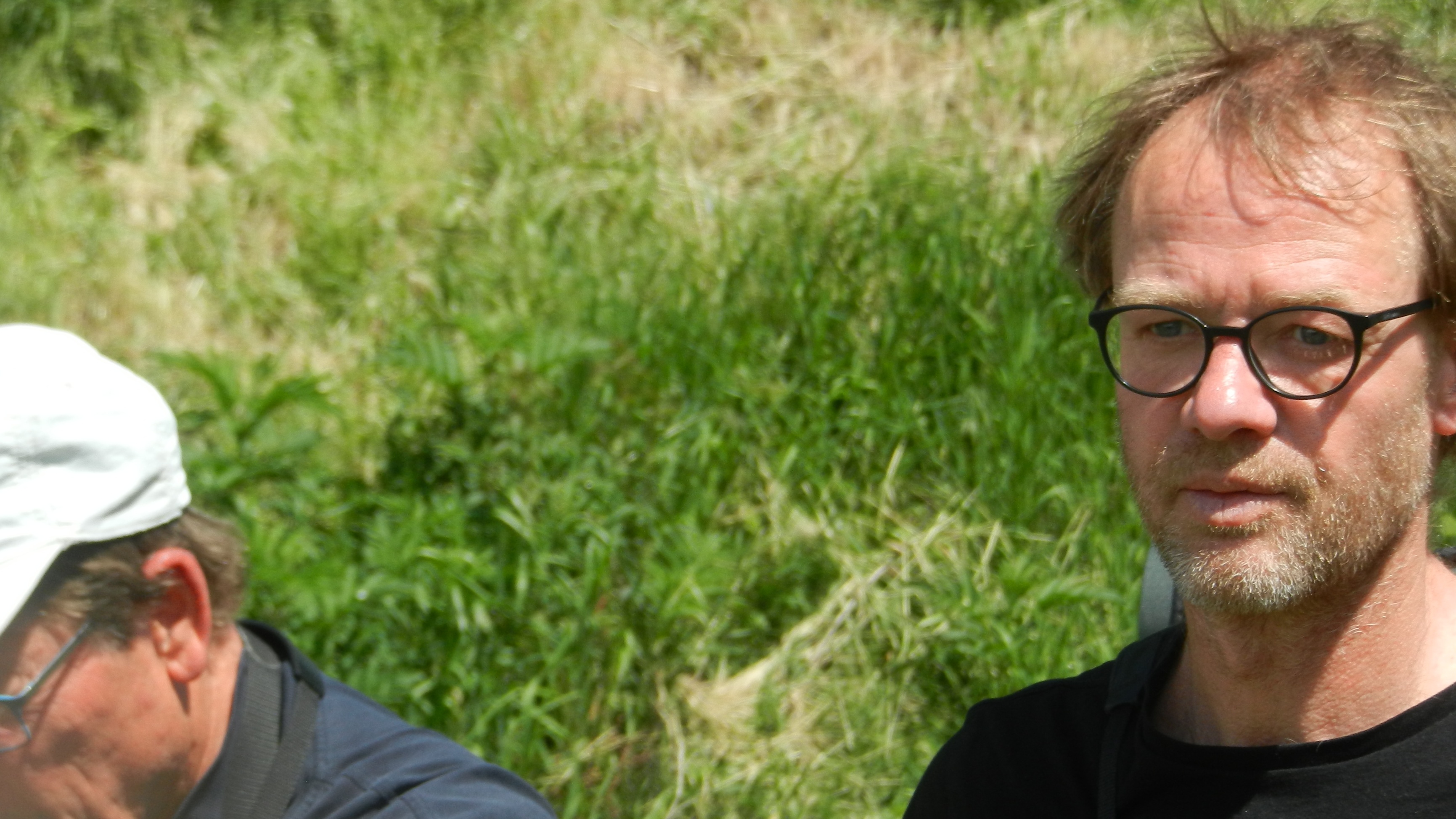 Lou Bertalan in Gedanken im freien Feld - es ist Frühling und das Gras leuchtet saftig grün